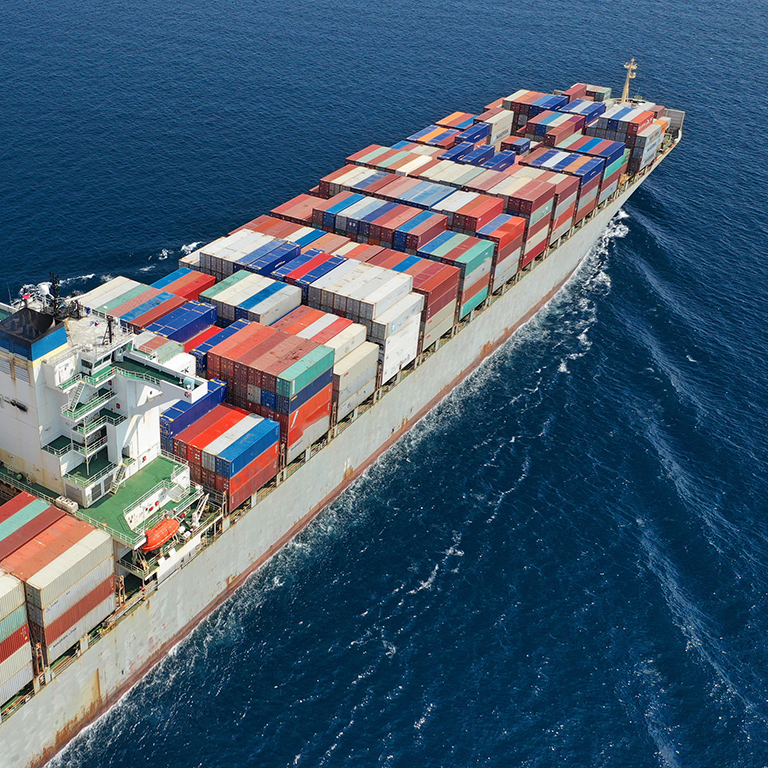 Aerial drone panoramic ultra wide photo of industrial container tanker ship cruising in open ocean deep blue sea.