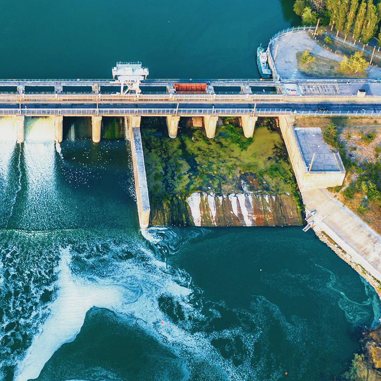 Aerial view of Dam at reservoir with flowing water, hydroelectricity power station, drone photo.