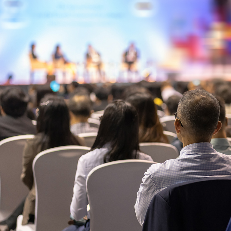 Rear view of Audience listening Speakers on the stage in the conference hall or seminar meeting, business and education about investment concept