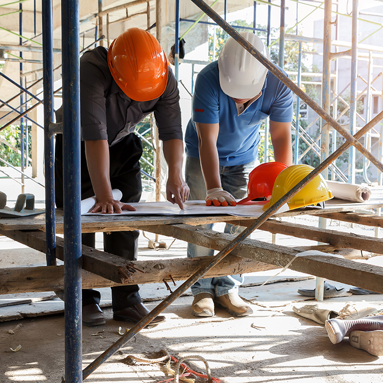 Engineer discussing with foreman about project in building construction site