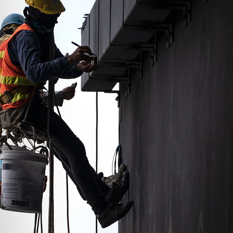 Construction worker wearing safety harness and safety line working at high place