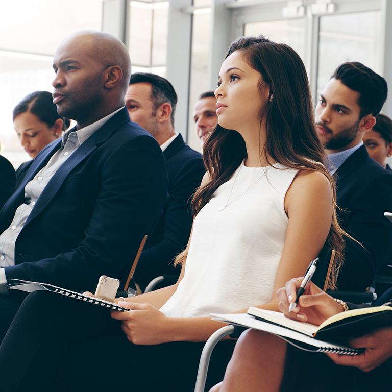 Business people, conference and audience in workshop training taking notes. Employee workers listening to coaching, presentation or meeting seminar for business strategy.