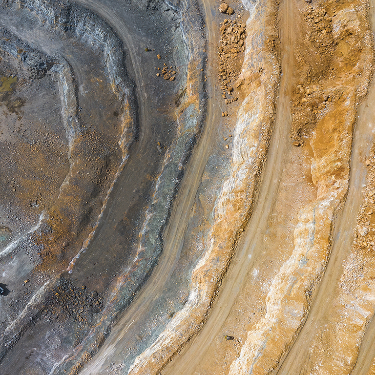 Mining from above. Industrial terraces on open pit  mineral mine. Aerial view of opencast mining. Dolomite Mine Excavation. Extractive industry. Giant excavator machineries