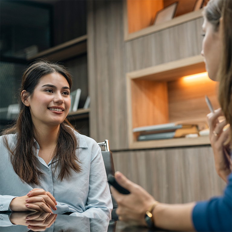 Recruiter holding candidate resume taking job interview at desk.