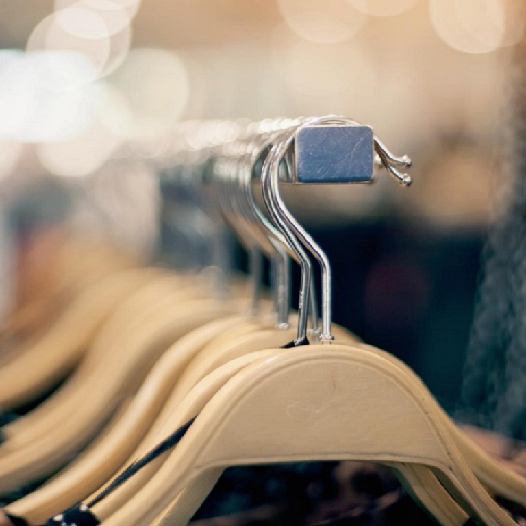 Shopping in store. Clothes on hangers in shop for sale.