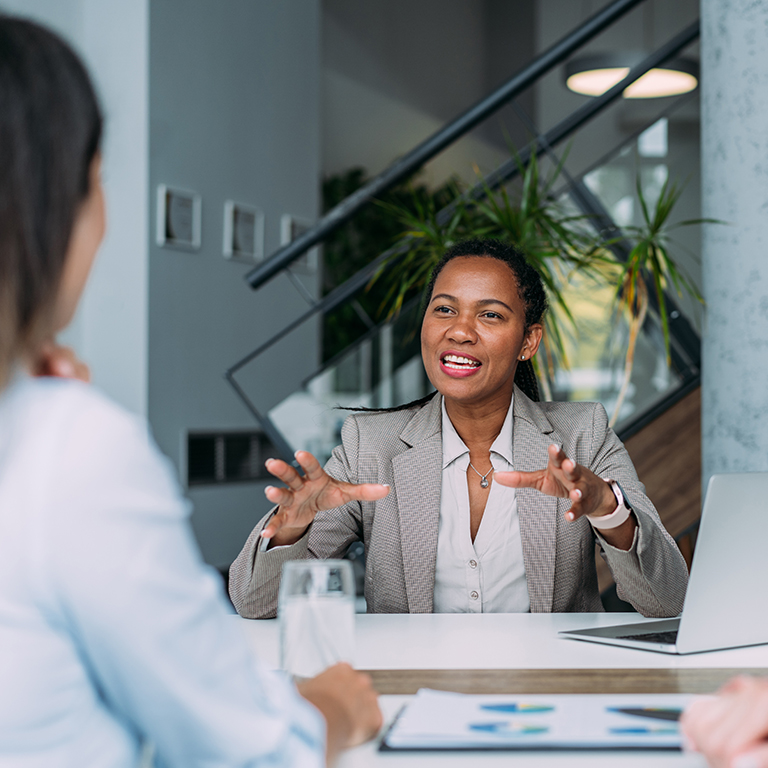 Three business women in board room meeting.