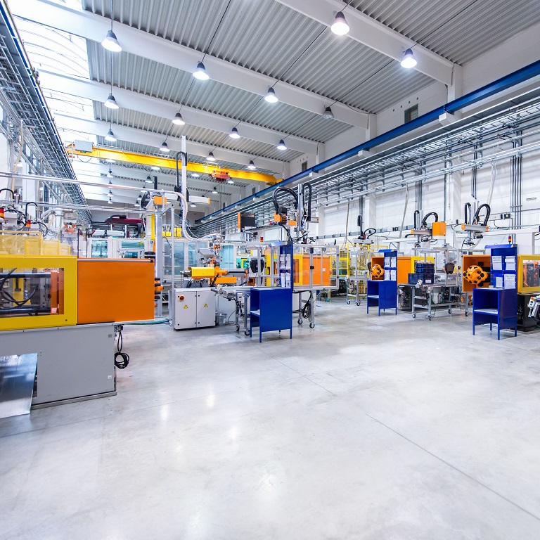 Horizontal image of huge new modern factory with robots and machines producing industrial plastic pieces and equipment. Wide angle view of futuristic machines standing on flooring and having the monopole of all work, taking the place of human work. There is not necessary use human hand. Wide angle, view, no people, space for copy.