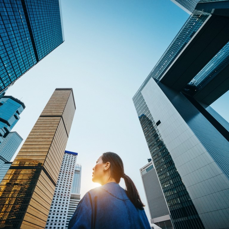 woman gazing at skyscrapers under sky