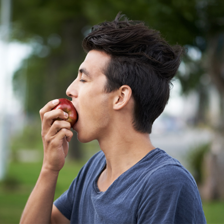 Young man taking a bite of an apple